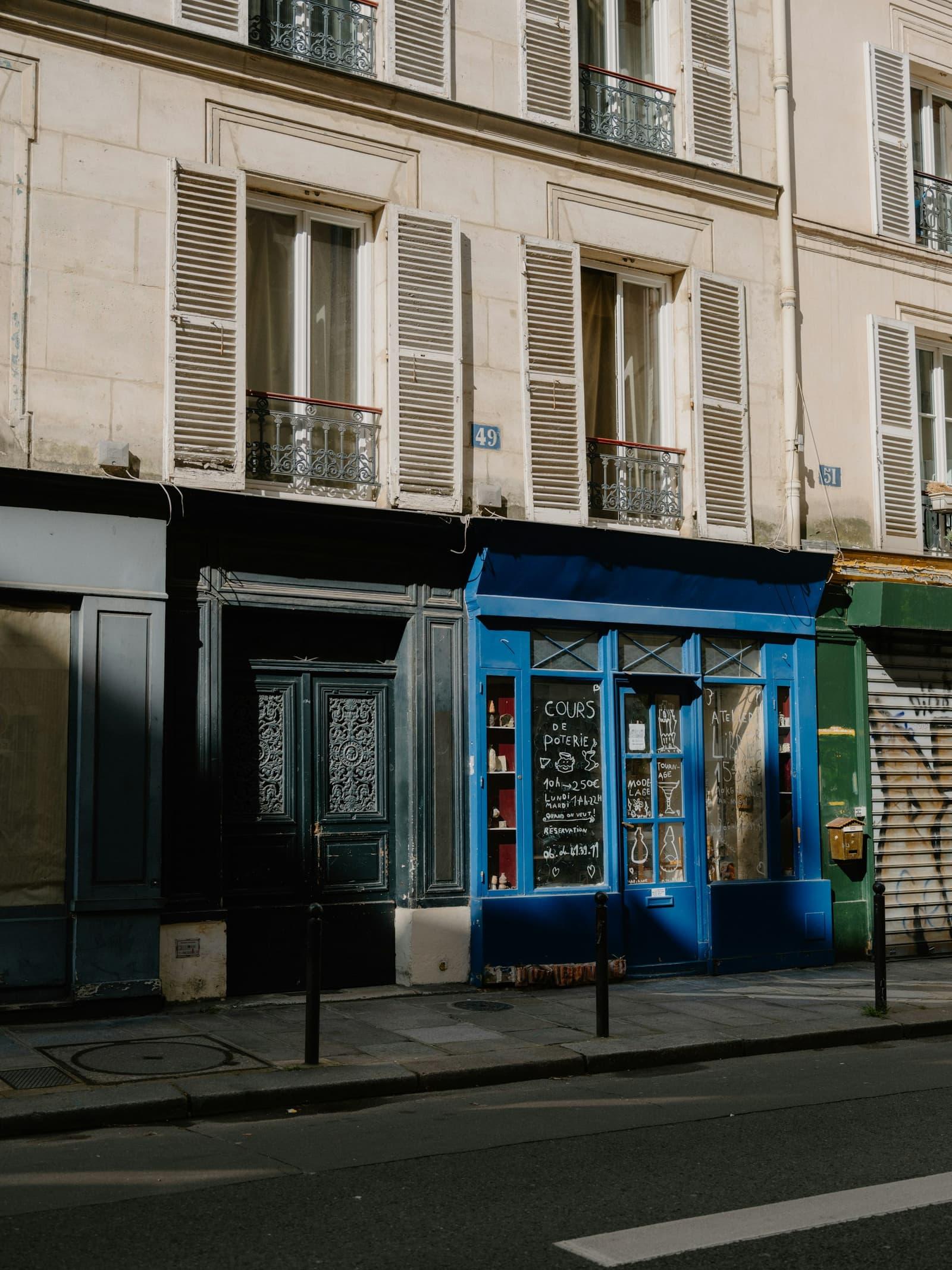 Devanture de commerce peinte en bleu dans une rue parisienne.
