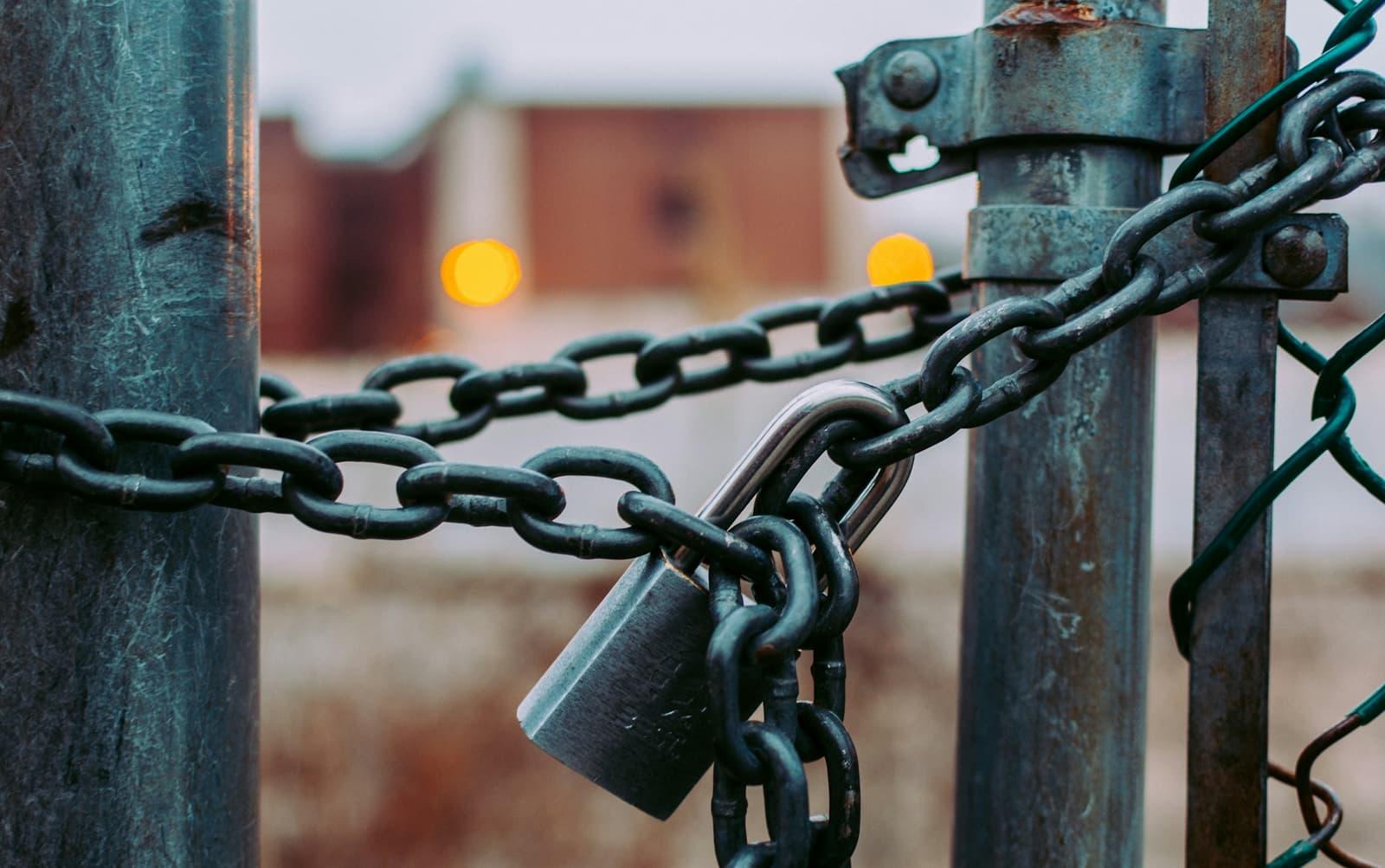 Cadenas d'acier fermant une chaîne sur un portail.