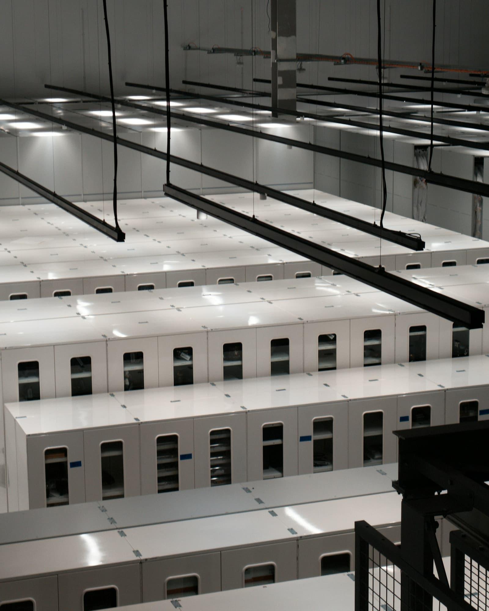 Rangées d'armoires serveurs dans une salle de données, vue de dessus.
