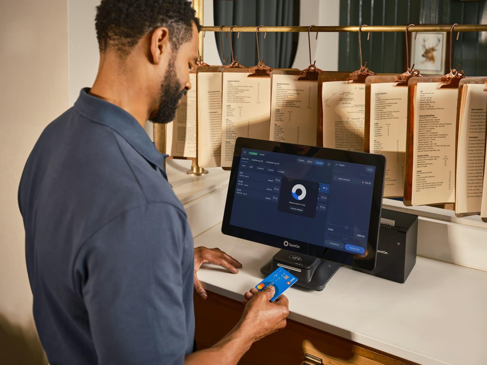 Client réglant par carte sur un terminal de paiement.