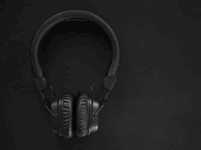 Casque audio circum-aural noir sur fond sombre.